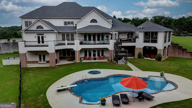 rear view of property featuring a patio area, a balcony, a swimming pool with hot tub, and french doors