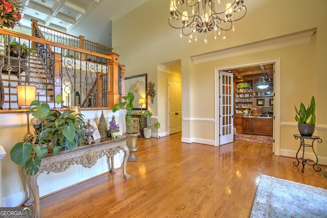 interior space with crown molding, coffered ceiling, hardwood / wood-style floors, and beamed ceiling