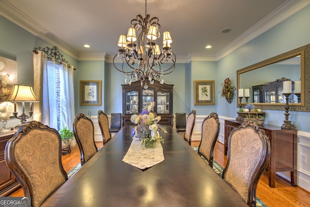 dining area featuring wood-type flooring, crown molding, and a chandelier