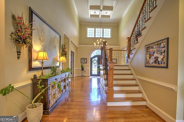 entrance foyer featuring hardwood / wood-style flooring, ornamental molding, and an inviting chandelier