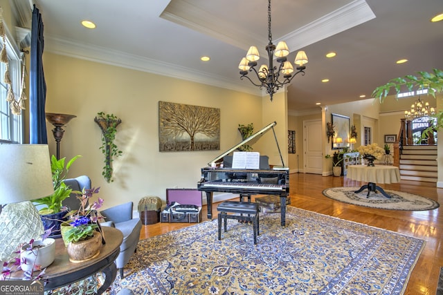 office area with wood-type flooring, a raised ceiling, ornamental molding, and a chandelier