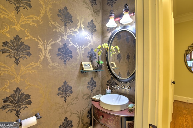 bathroom featuring wood-type flooring, vanity, and crown molding