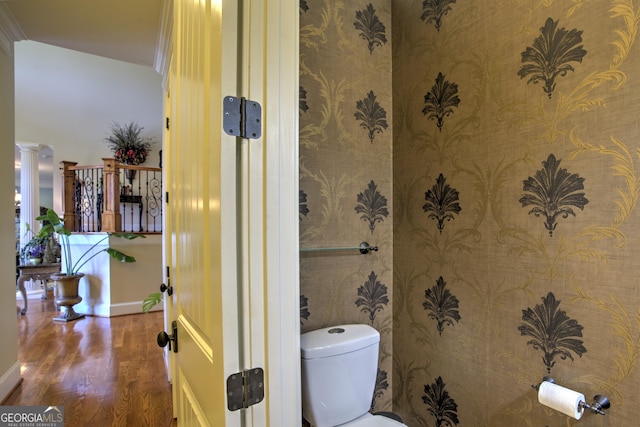 bathroom with hardwood / wood-style flooring, toilet, and crown molding