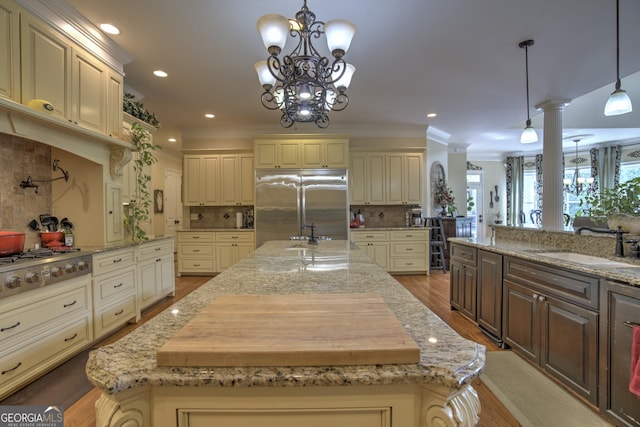 kitchen featuring a center island, tasteful backsplash, sink, pendant lighting, and stainless steel appliances