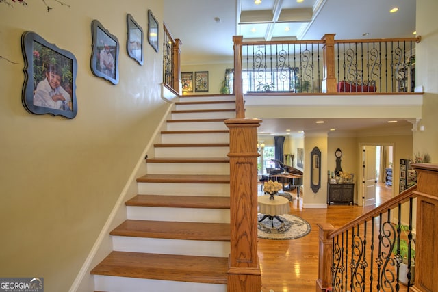 staircase featuring ornamental molding and hardwood / wood-style floors