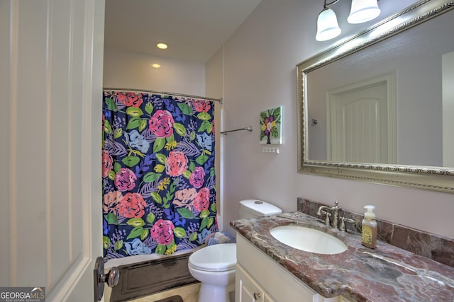 bathroom with toilet, vanity, and walk in shower