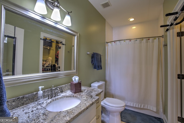 bathroom with toilet, a shower with shower curtain, and vanity