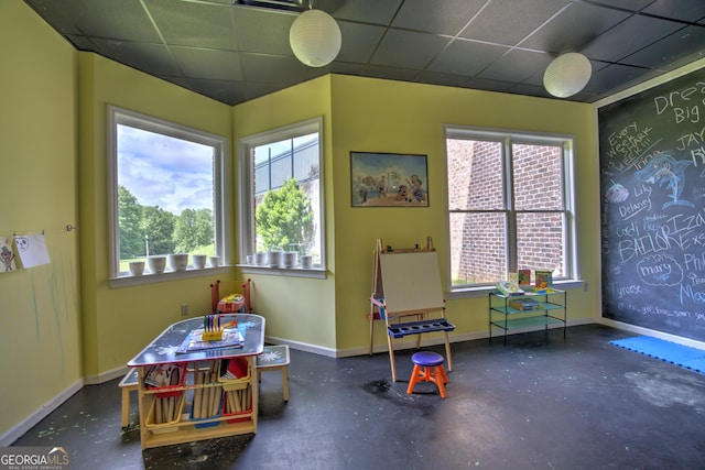 playroom featuring a paneled ceiling and plenty of natural light