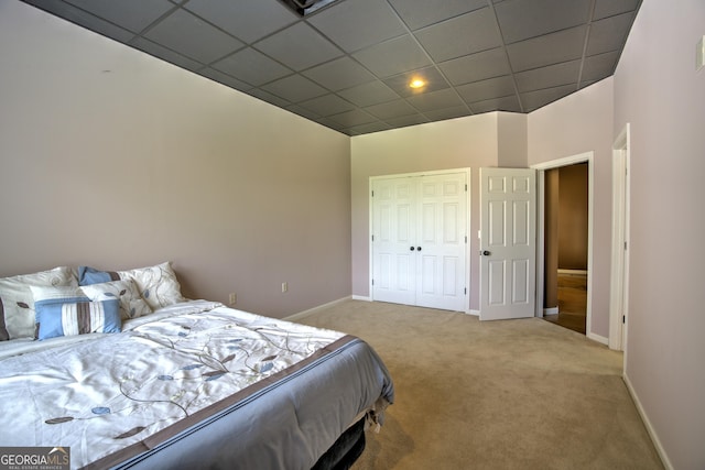 bedroom featuring a closet, carpet, and a paneled ceiling