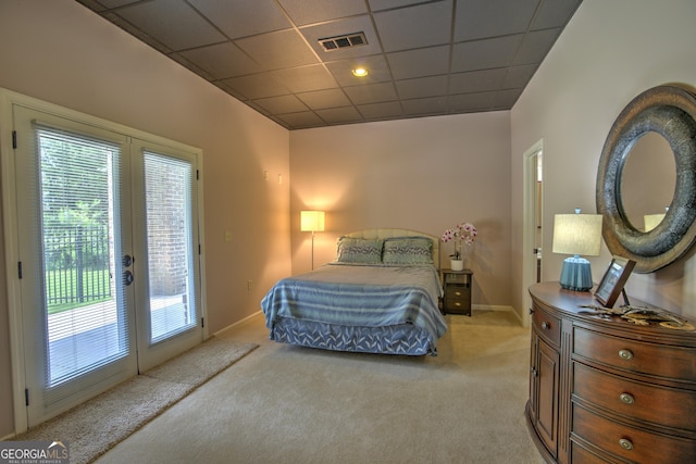 carpeted bedroom featuring access to exterior, a drop ceiling, and french doors