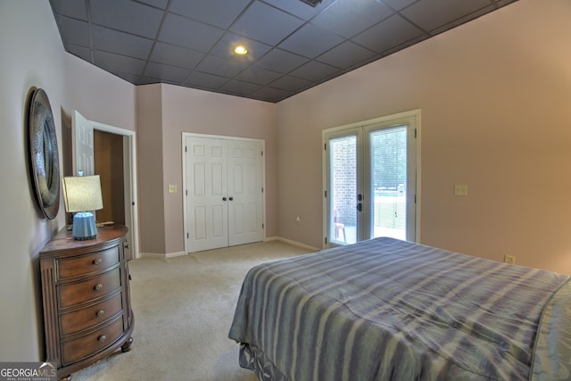 carpeted bedroom featuring a paneled ceiling, access to exterior, a closet, and french doors