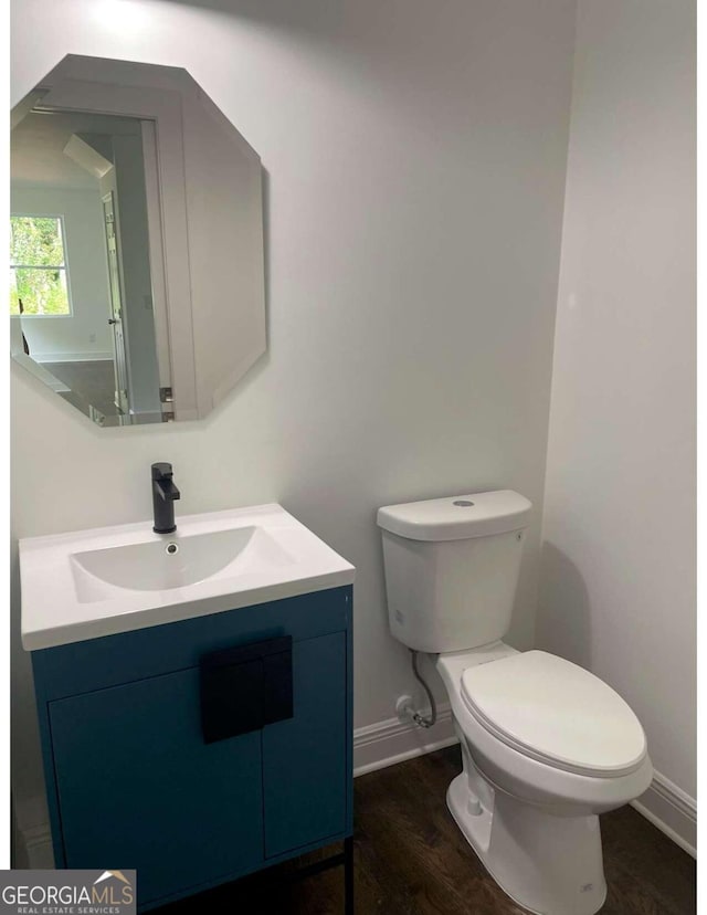 bathroom with toilet, vanity, and hardwood / wood-style floors