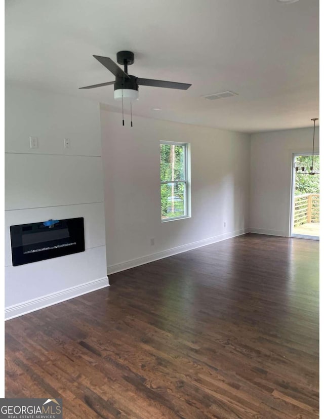 unfurnished living room with ceiling fan and dark hardwood / wood-style flooring