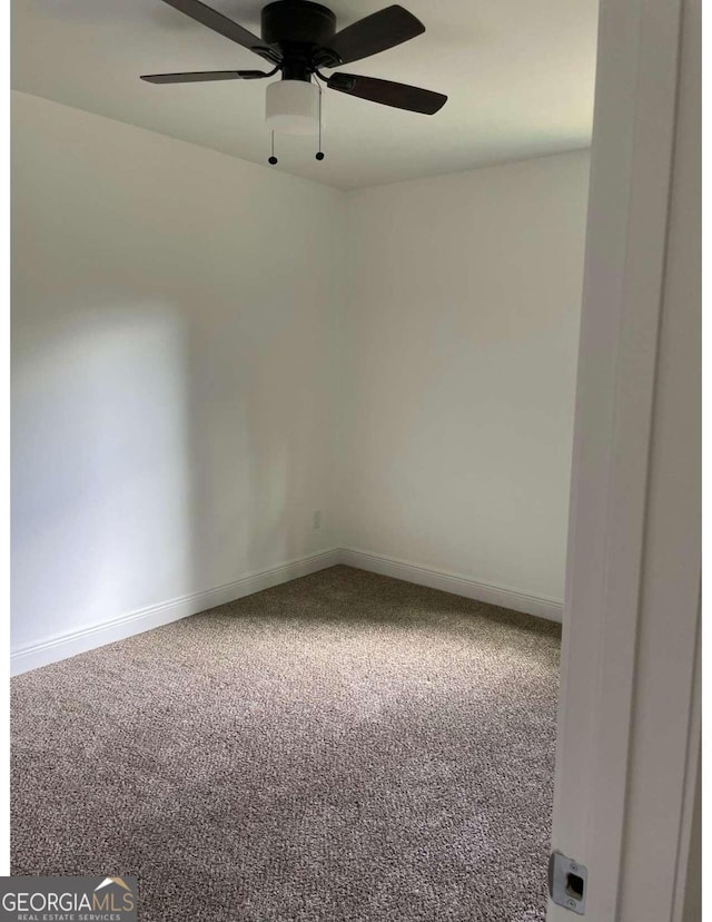 carpeted spare room with ceiling fan