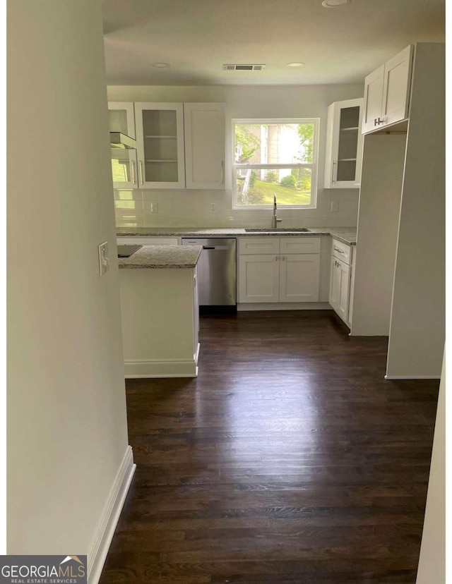 kitchen with white cabinets, stainless steel dishwasher, light stone counters, and sink