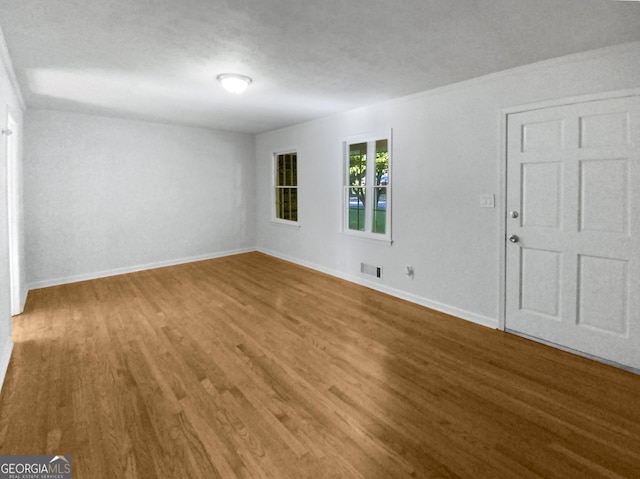 spare room with hardwood / wood-style floors and a textured ceiling