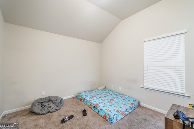 carpeted bedroom with lofted ceiling