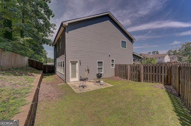 rear view of property with a lawn and a patio