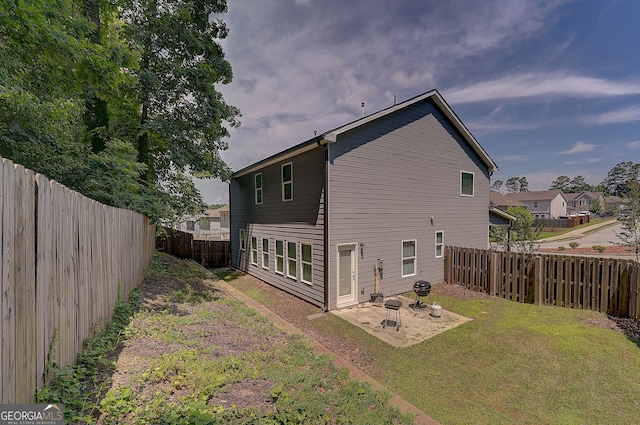 back of house with a patio area and a yard