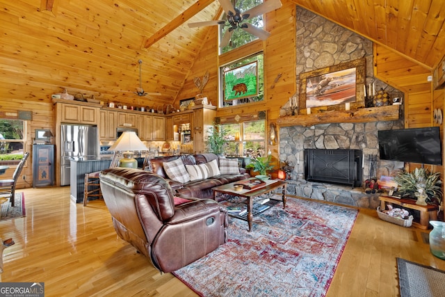 living room with light hardwood / wood-style flooring, high vaulted ceiling, and wood walls