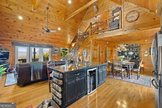 kitchen with light hardwood / wood-style floors, high vaulted ceiling, and wooden walls