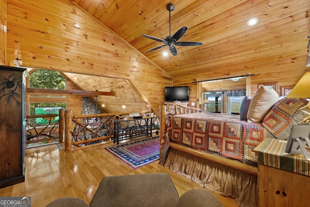 bedroom featuring light hardwood / wood-style floors, multiple windows, wooden walls, and lofted ceiling