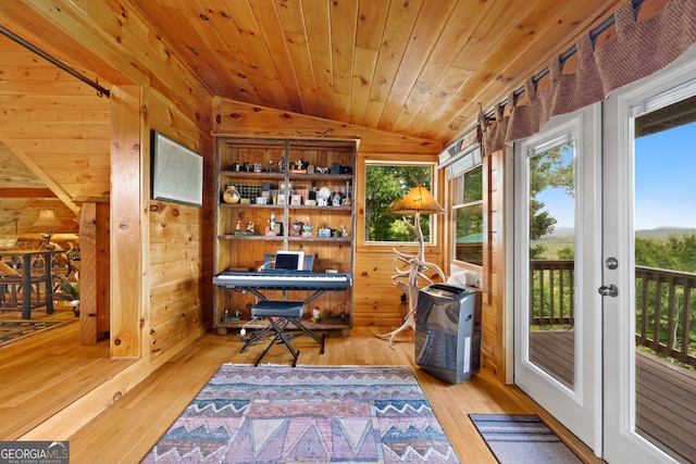 home office featuring light hardwood / wood-style flooring, wood walls, and lofted ceiling