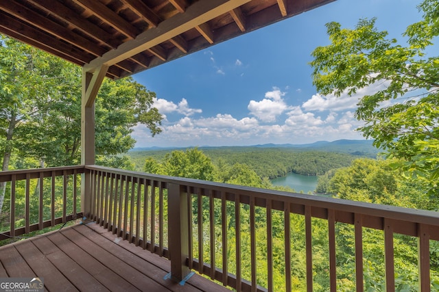 deck featuring a water and mountain view and a forest view