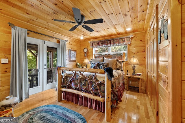 bedroom with ceiling fan, wood walls, access to exterior, wooden ceiling, and hardwood / wood-style flooring