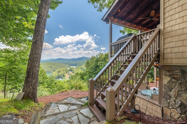 view of yard with ceiling fan, a mountain view, and stairway
