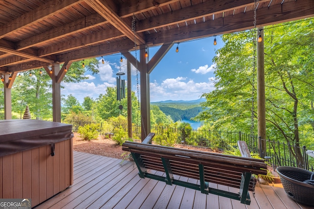 wooden terrace featuring a hot tub and a mountain view