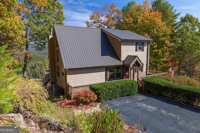 view of front of property with central AC unit and metal roof