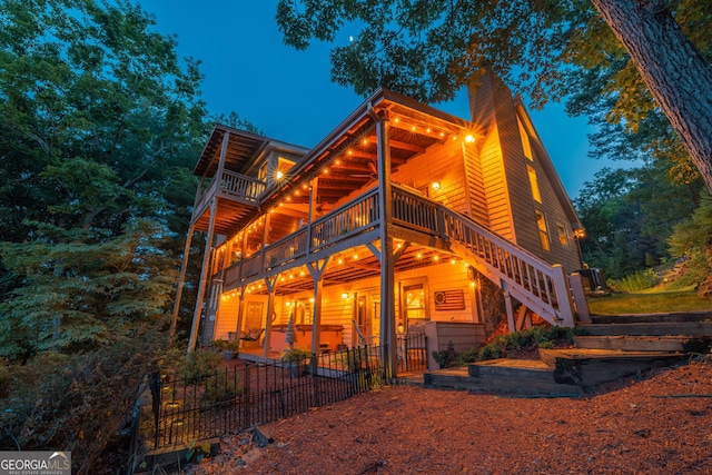 back of house with fence, a wooden deck, stairway, a chimney, and a patio