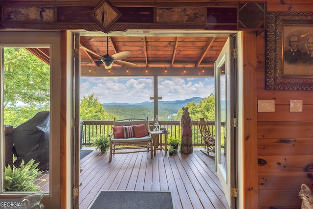 wooden deck with ceiling fan and a mountain view