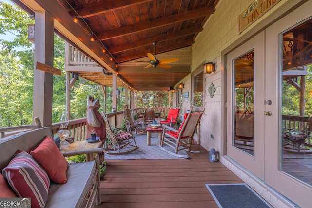 wooden terrace featuring ceiling fan and an outdoor living space