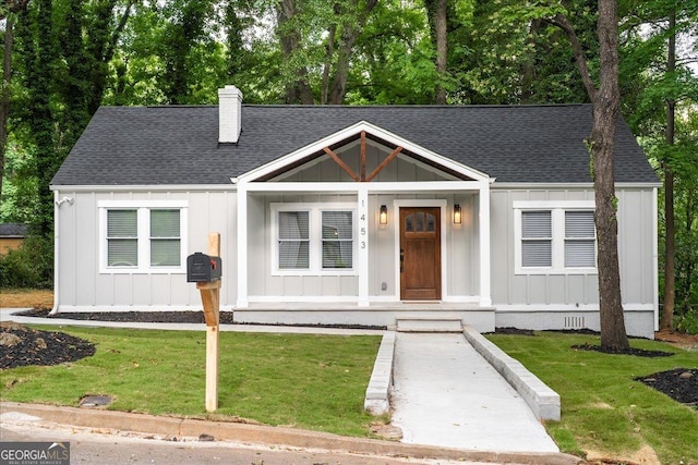 view of front of home with a porch and a front lawn