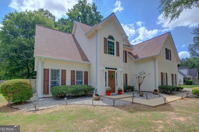 view of front of property with a front yard and roof with shingles