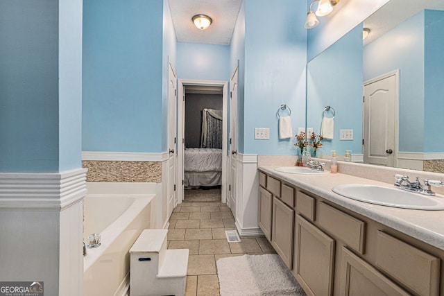 104 Streambank Ct, Temple, GA 30179 - bathroom with double vanity, a bath, ensuite bath, and wainscoting