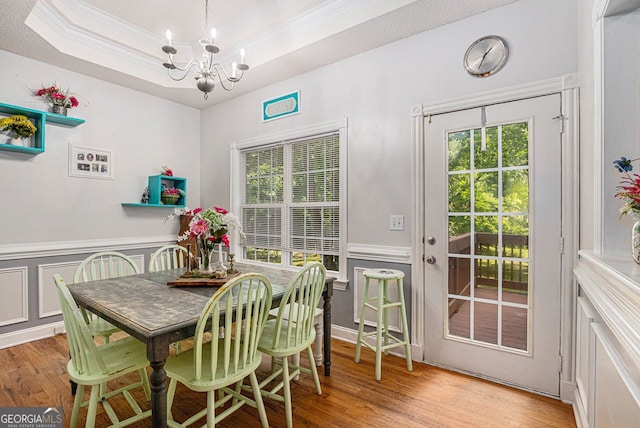 104 Streambank Ct, Temple, GA 30179 - dining room featuring a chandelier, ornamental molding, wood finished floors, a wainscoted wall, and a tray ceiling