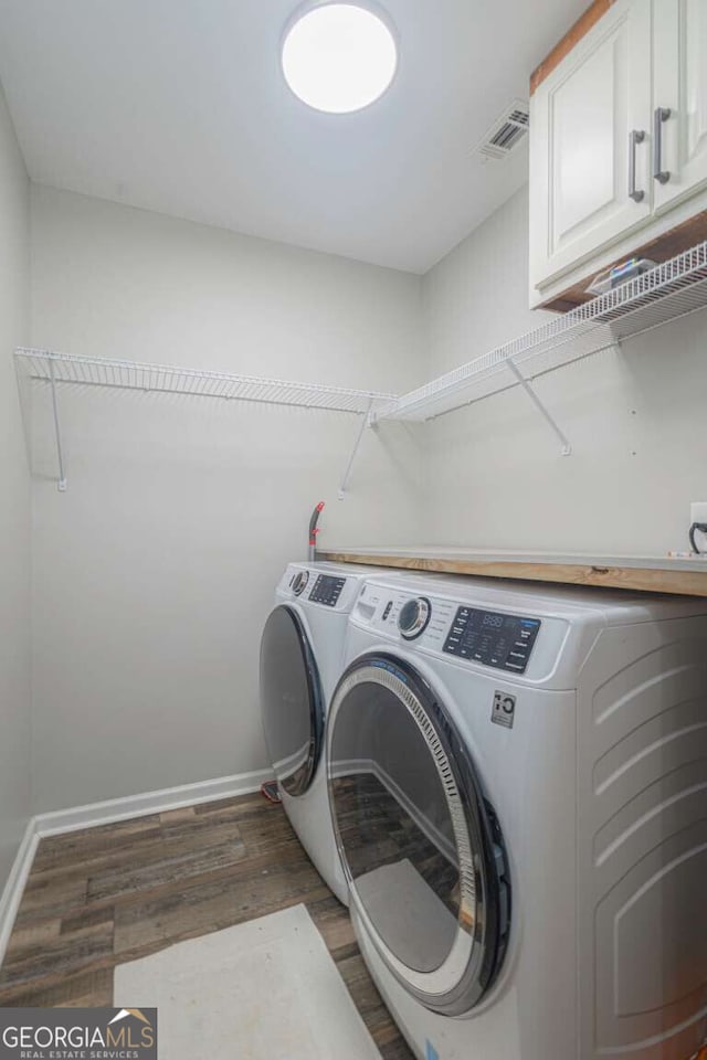 1985 Roscoe Rd, Newnan, GA 30263 - washroom featuring cabinet space, baseboards, dark wood-type flooring, and washer and dryer
