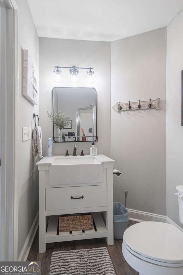 1985 Roscoe Rd, Newnan, GA 30263 - bathroom featuring baseboards, vanity, toilet, and wood finished floors