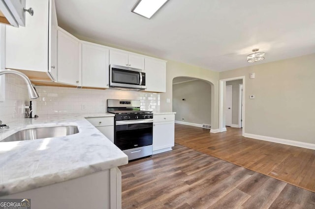 kitchen with white cabinetry, sink, appliances with stainless steel finishes, and dark wood-type flooring