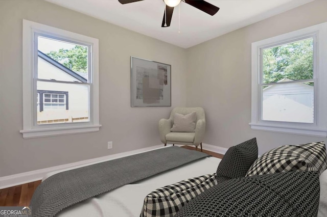 bedroom featuring hardwood / wood-style flooring, ceiling fan, and multiple windows