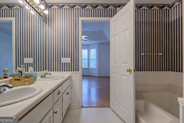 bathroom featuring vanity, a tub to relax in, and wood-type flooring