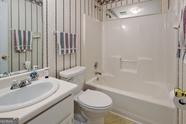 full bathroom with vanity, washtub / shower combination, toilet, and tile patterned flooring