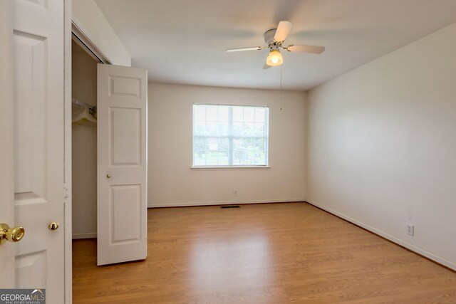 unfurnished bedroom featuring light hardwood / wood-style flooring, a closet, and ceiling fan