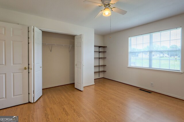 unfurnished bedroom with light hardwood / wood-style flooring, a closet, and ceiling fan