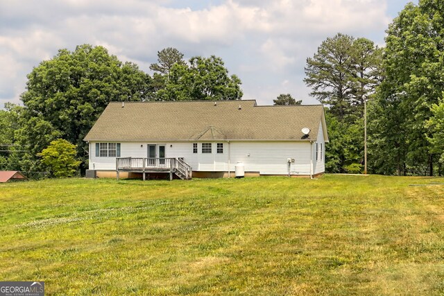 rear view of property featuring a yard and a deck