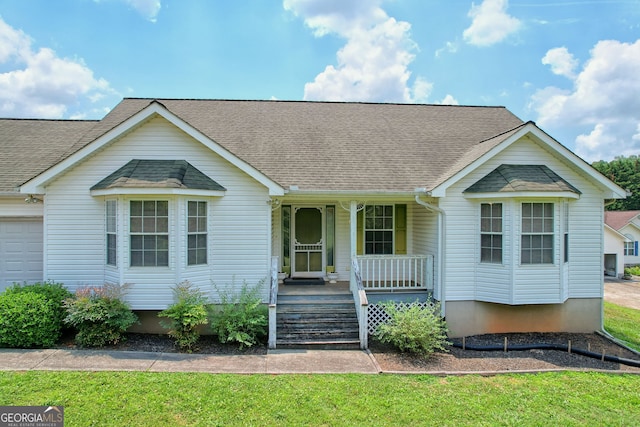 ranch-style house with a front yard, a garage, and a porch