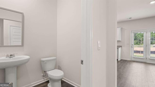 bathroom with hardwood / wood-style floors, toilet, and sink